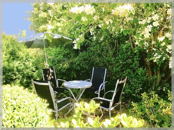 Gemütliche Sitzecke im Grünen der Pension Deparade Altenburg mit Gartenmöbeln und Bäumen